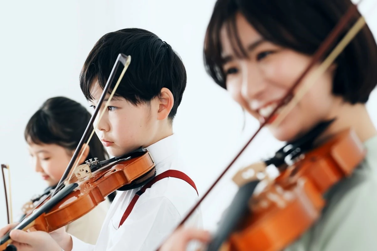 Children learning the violin with a violin teacher